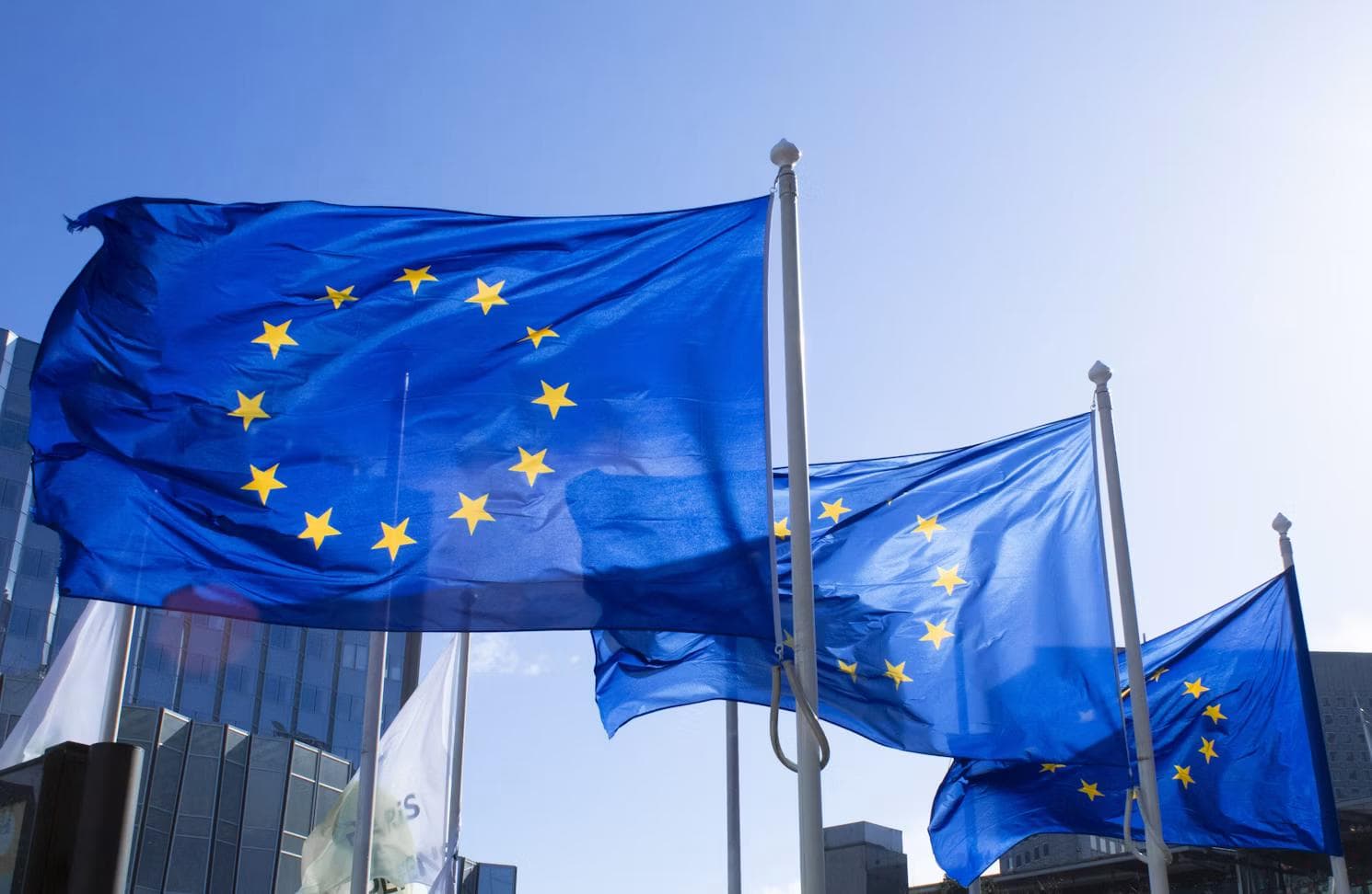 EU-flagg vaier på flaggstenger utenfor en bygning