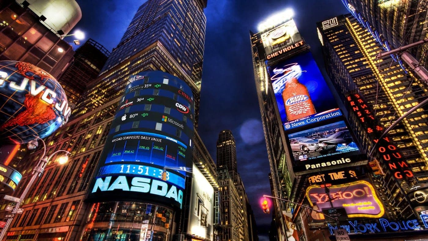 Times Square om kvelden med opplyst Nasdaq-skilt og reklametavler