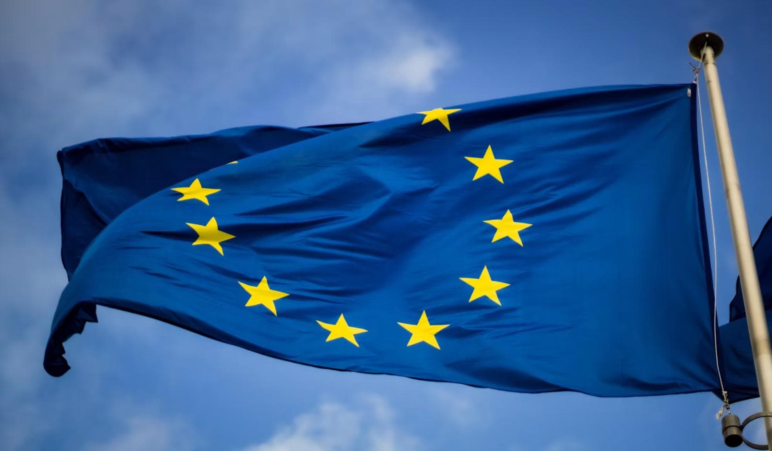 EU-flagget med gule stjerner mot blå himmel
