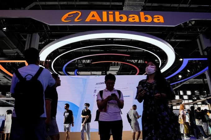 Alibaba-logoen over en utstillingsstand med besøkende